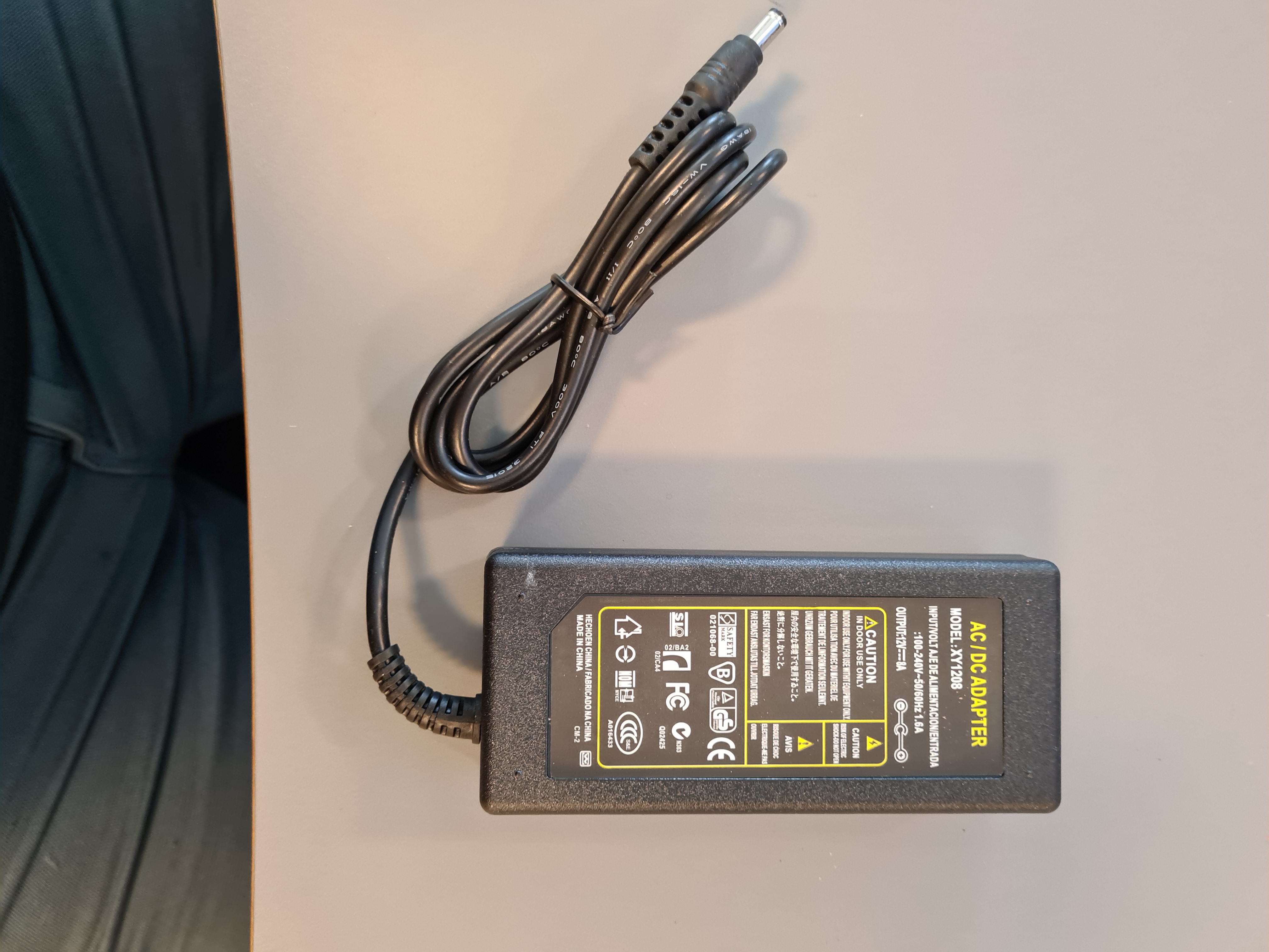 Billede fra myndighedens meddelelse af det tilbagekaldte produkt AC/DC Adapter 8A. Årsag: OKTILTAG.