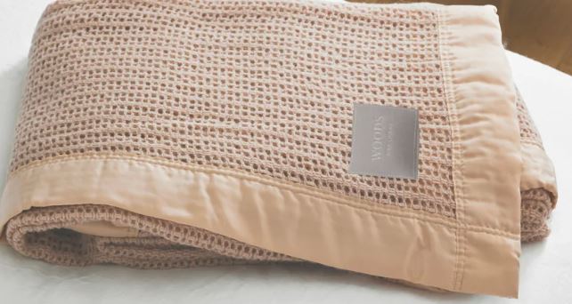 Billede fra myndighedens meddelelse af det tilbagekaldte produkt UK - Woods Pure New Wool 'Cellular' Blanket. Årsag: OKTILTAG.