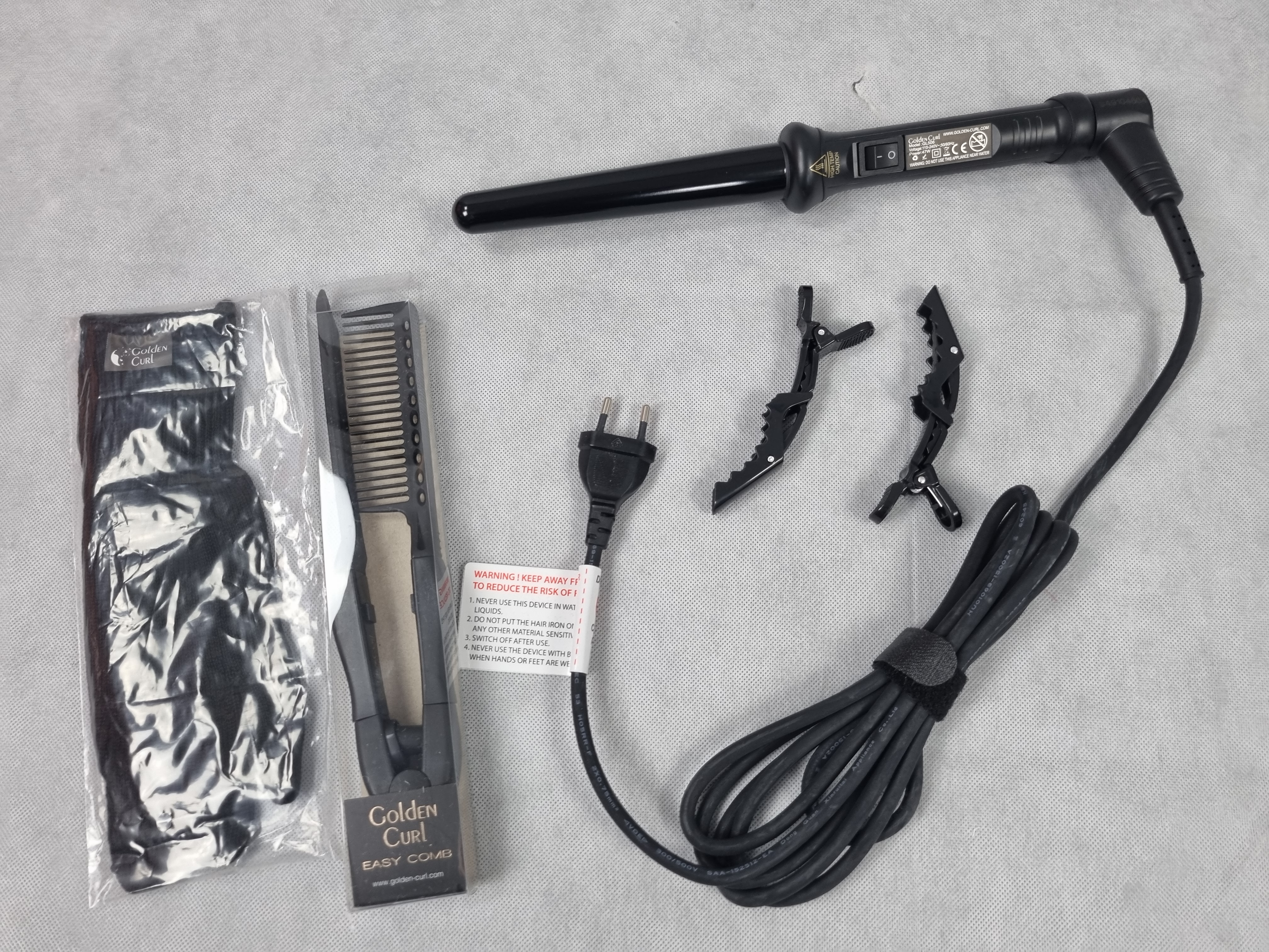 Billede fra myndighedens meddelelse af det tilbagekaldte produkt The Golden Curl Deutschland Curler (25-18mm). Årsag: OKTILTAG.