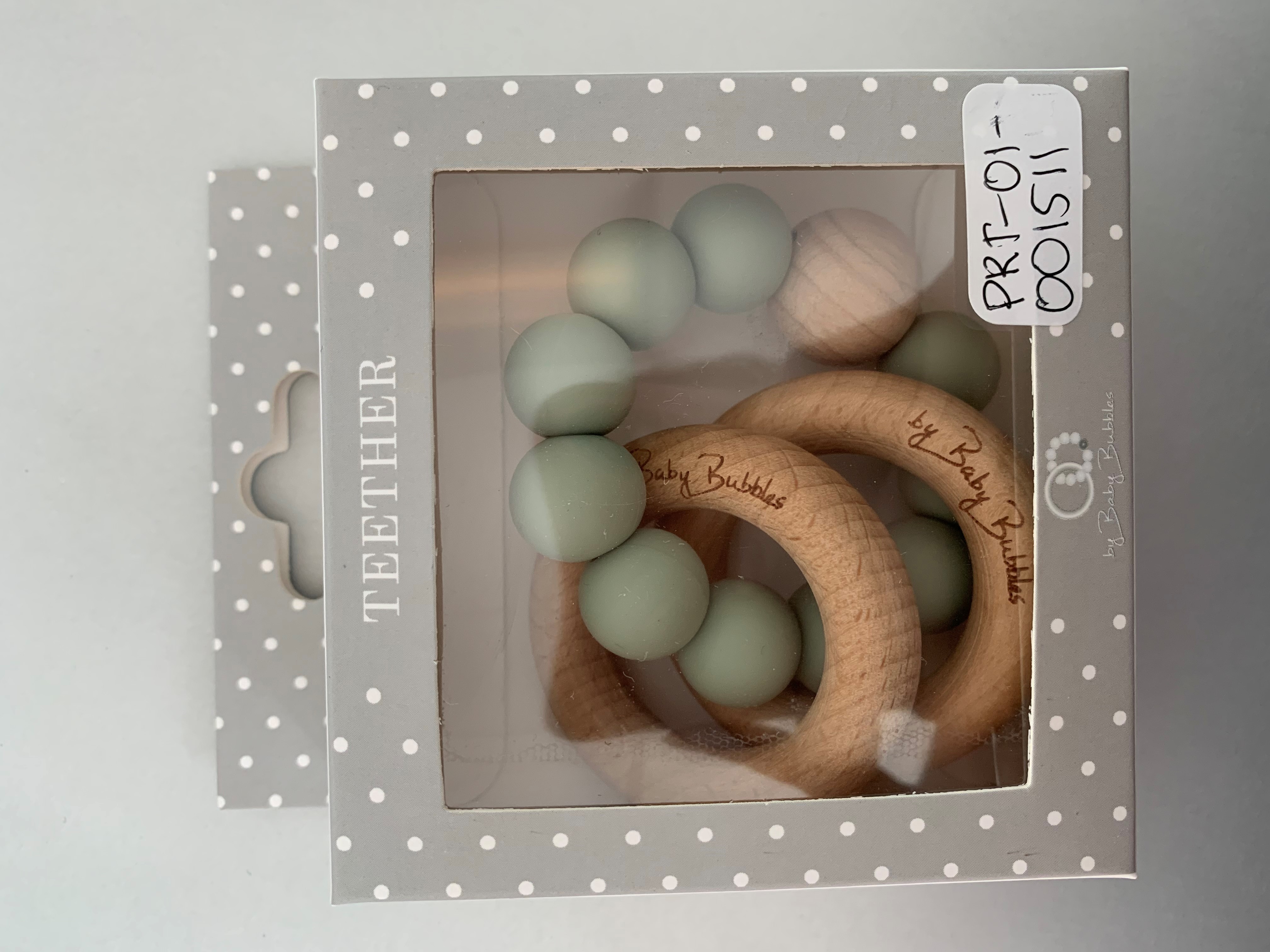 Billede fra myndighedens meddelelse af det tilbagekaldte produkt Biderangle fra ByBabyBubbles - Simple Sage. Årsag: OKTILTAG.