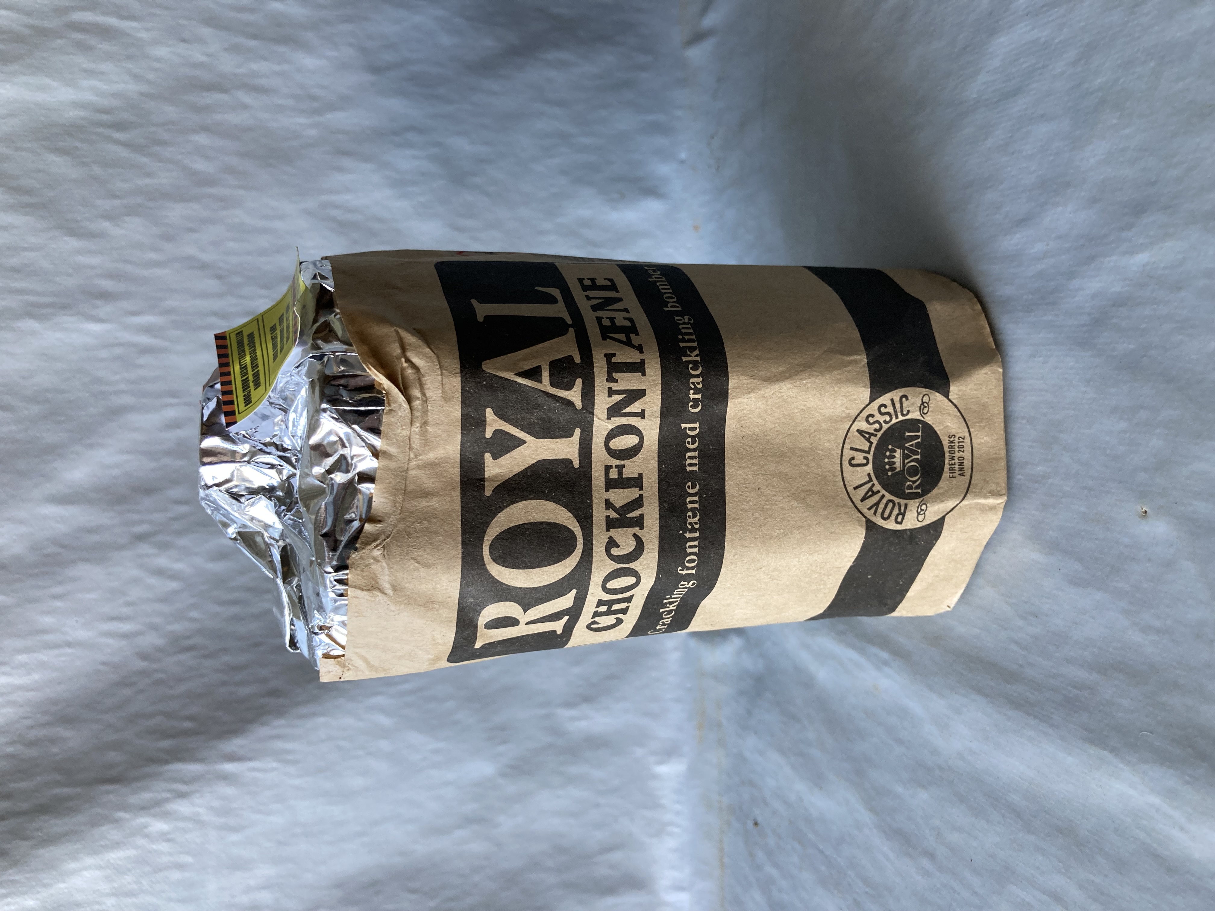 Billede fra myndighedens meddelelse af det tilbagekaldte produkt NYE - Royal Chockfontæne, CE-reg. nr. 1170-F2-02110, vare nr. 13.0800, batch nr. 21-15303, NEM 101,4 g. Årsag: OVERTRÆD.