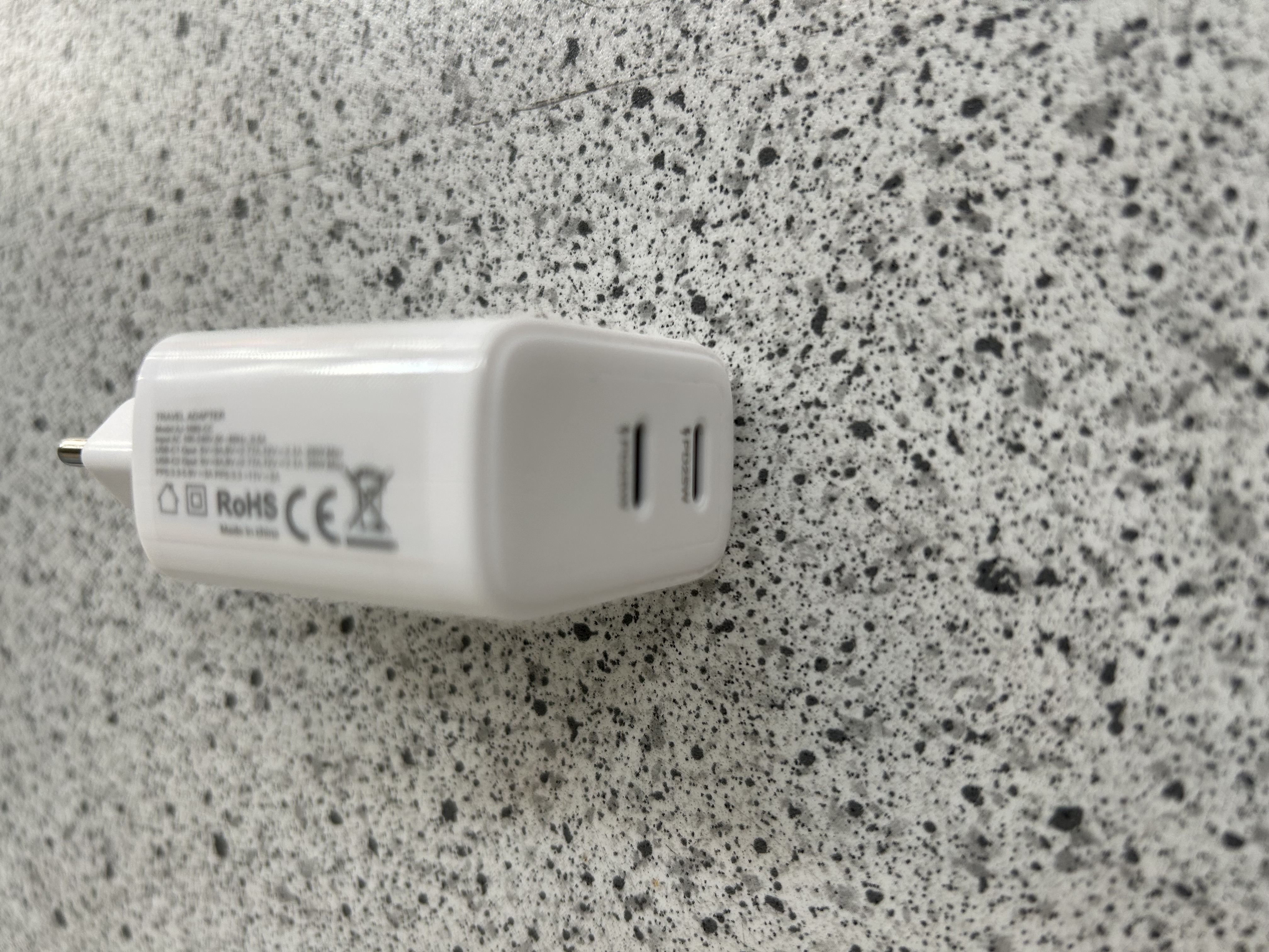 Billede fra myndighedens meddelelse af det tilbagekaldte produkt Travel adapter. Årsag: OVERTRÆD.